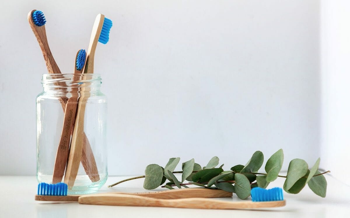 blue and white toothbrush in clear glass jar